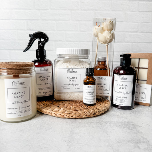 Collection of MillTown products including candles, bottles, and jars on a textured surface with a light background. Thomaston, GA