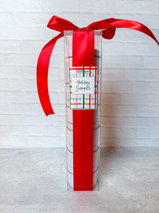 Gift package with red ribbon and 'Holidays Sampler' label on a light gray background
